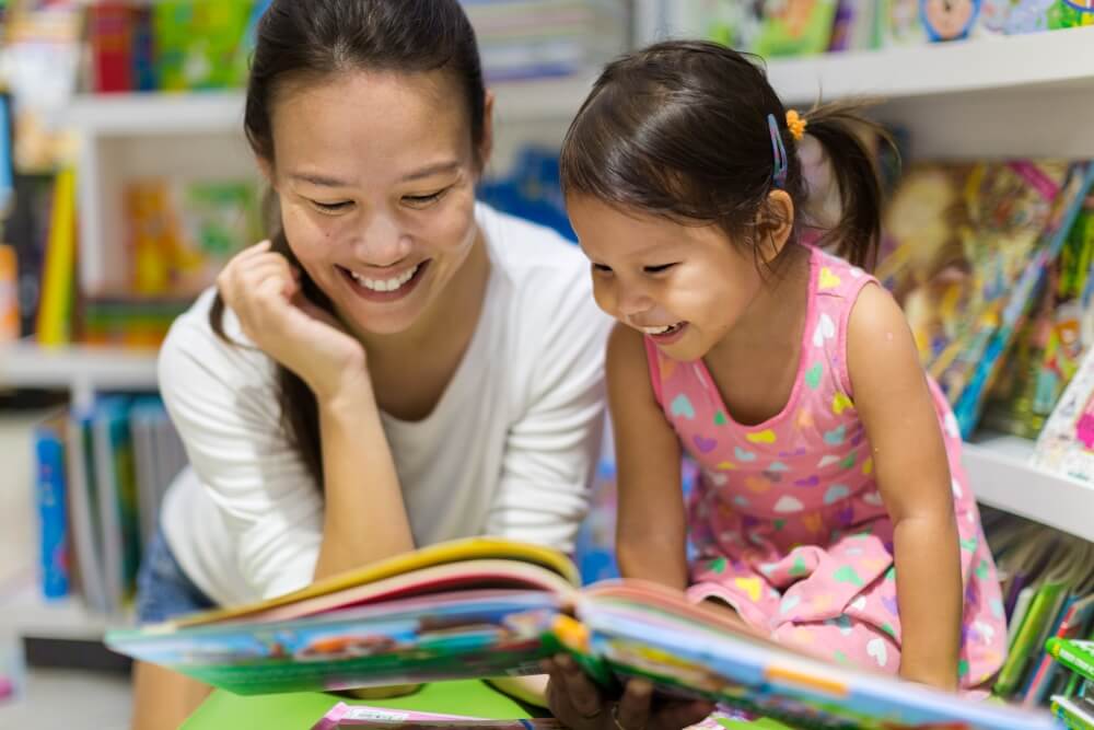 mother reading book to daughter