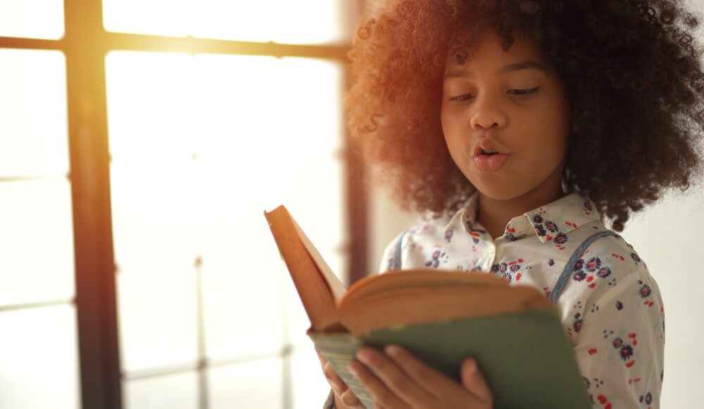 young girl reads a book