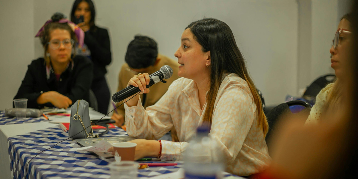 Young woman speaking confidently into microphone during debate