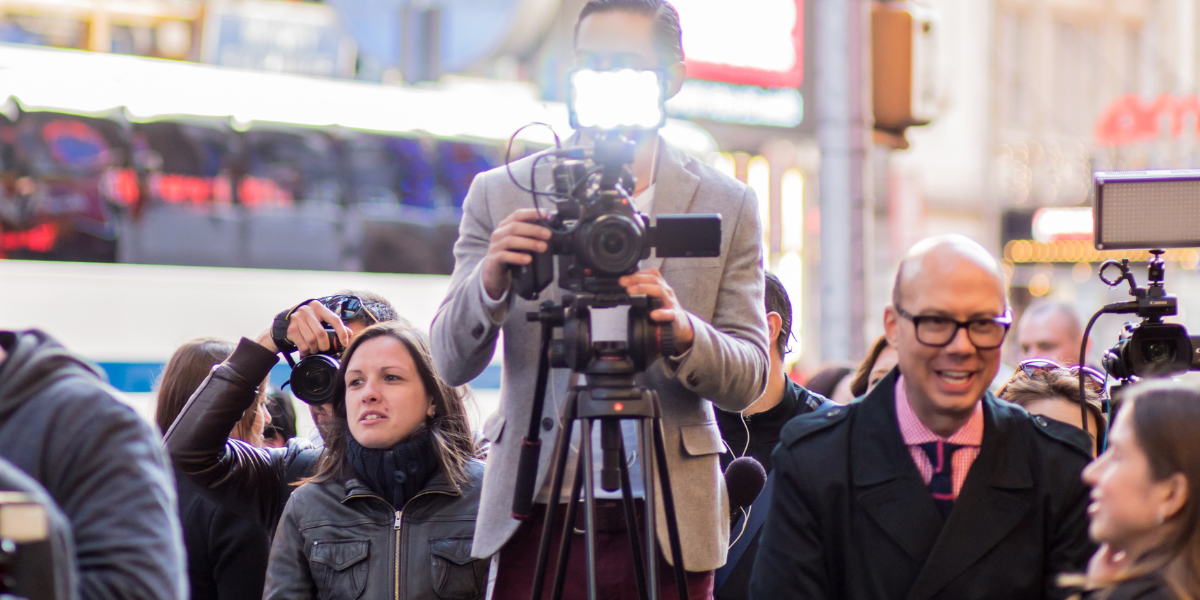 Citizen journalists with professional cameras and recording equipment covering news event