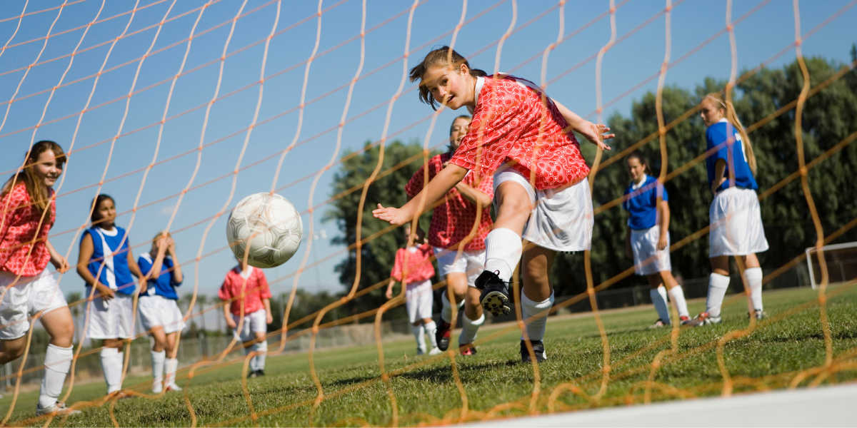 Young girls playing competitive soccer game highlighting gender equality in youth sports