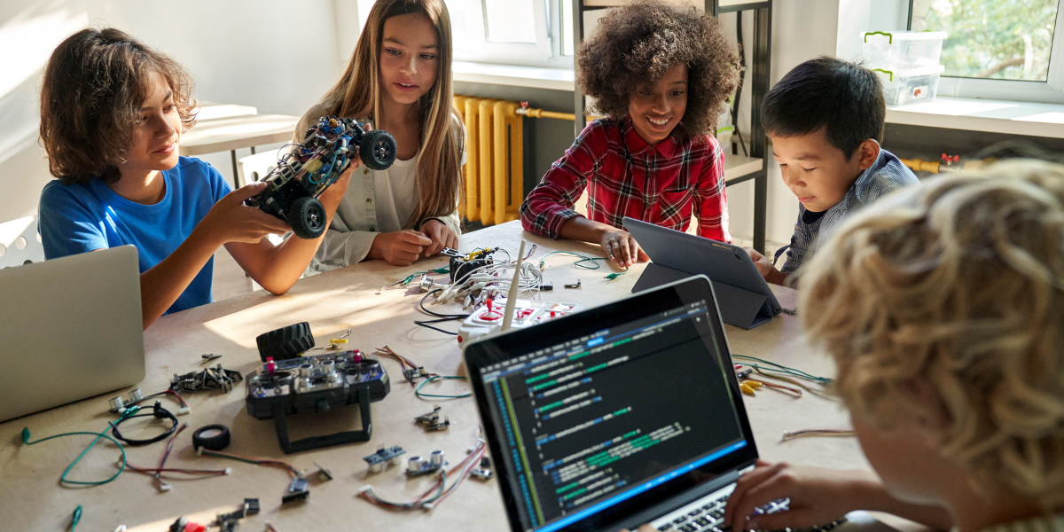 Diverse group of children working on robotics, coding, and engineering projects together, showing teamwork and STEM collaboration in educational setting
