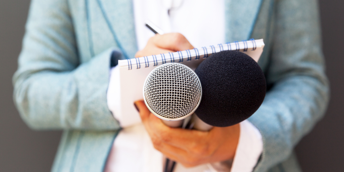 Student reporter with microphone and notepad learning to write news copy for school newspaper