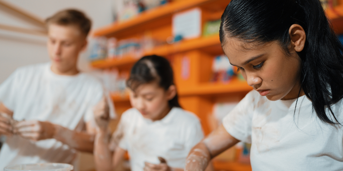 Students work quietly on individual art projects in a bright classroom setting, illustrating the focused learning environment created when educators teach art in schools to develop student creativity and critical thinking skills.
