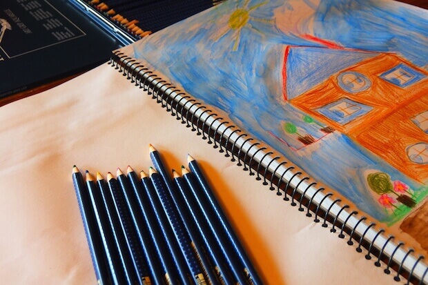 pencil crayons and child drawing - teacher looping pros and cons article featured image