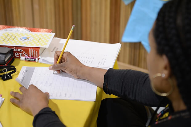 Judge at spelling bee contest making notes - article featured image on the cons of spelling bee contests