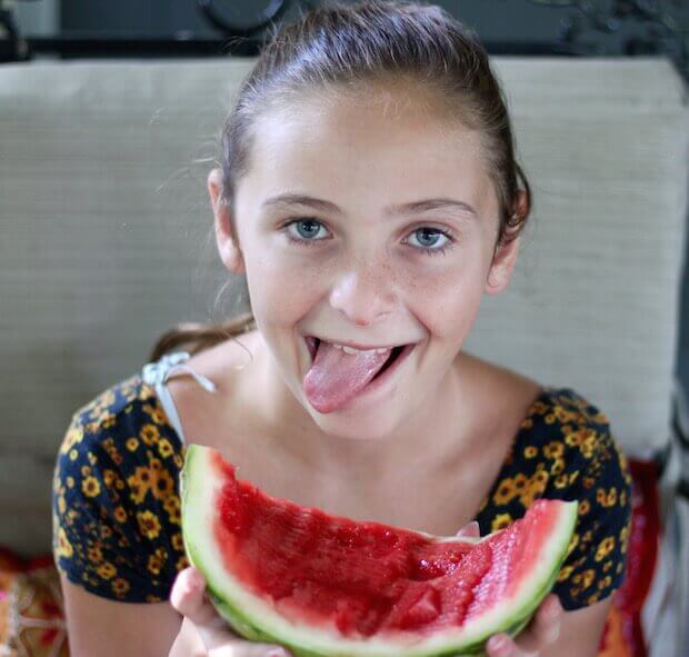 girl eating watermelon - kids health nutrition steps article featured image